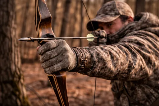 Bowhunter at full draw with a traditional recurve and a relaxed bow hand