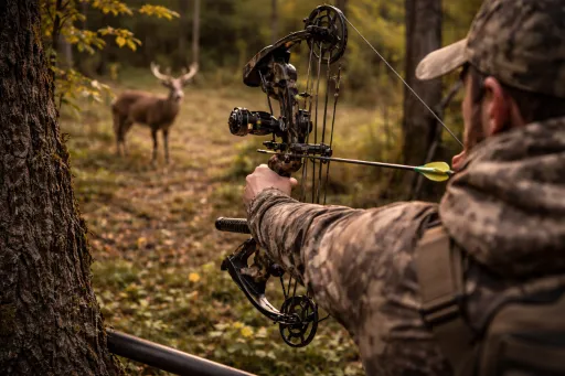 Bowhunter holding a Mathews ready to hunt bow package in the field